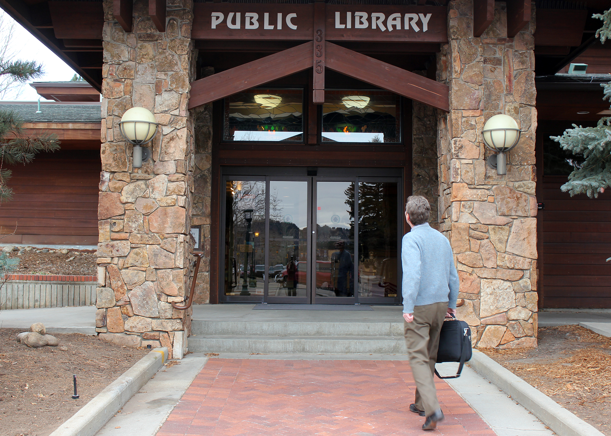 man walking up to entrance of public library